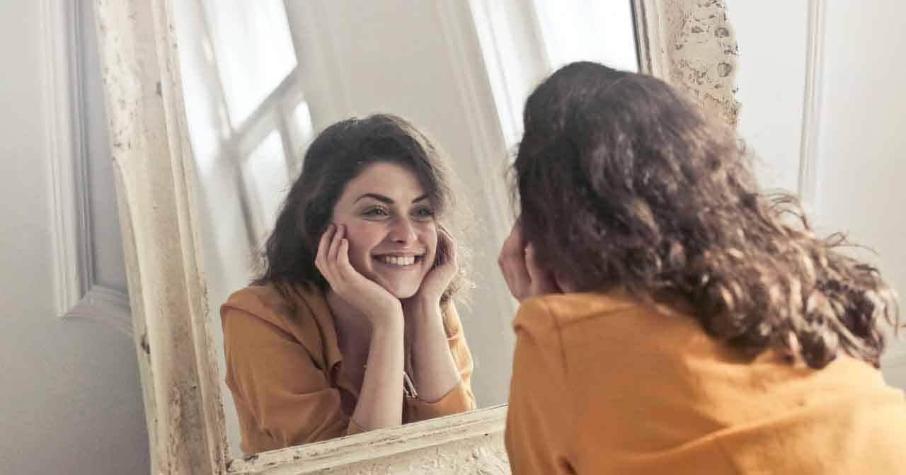 woman looking at herself in the mirror