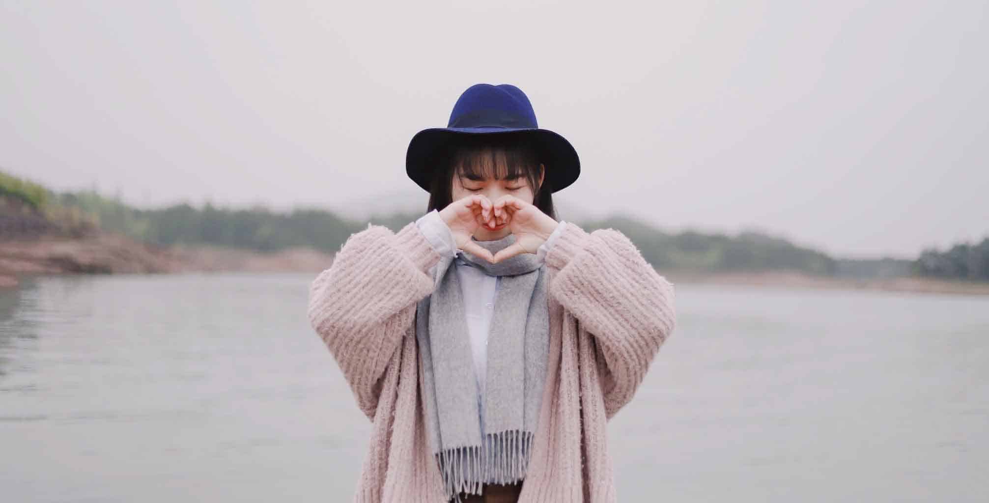 woman creating a heart with her hands