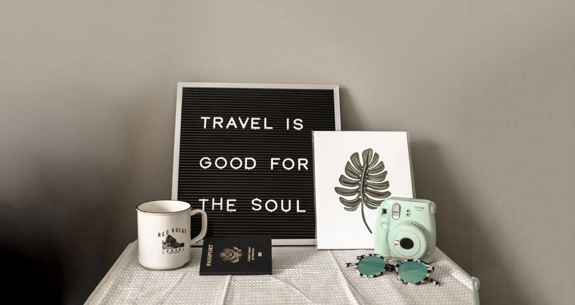 camera cop and sign saying traveling is good for the soul