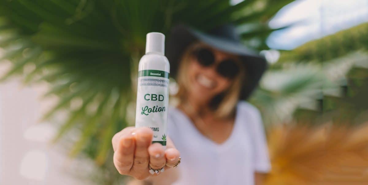 woman holding CBD oil lotion