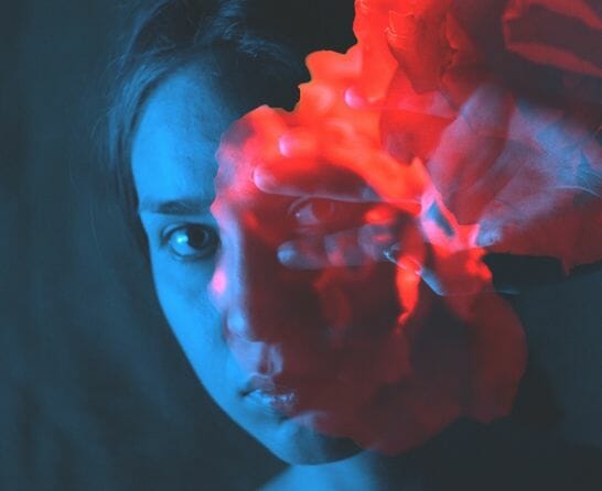 women moving red smoke from her face