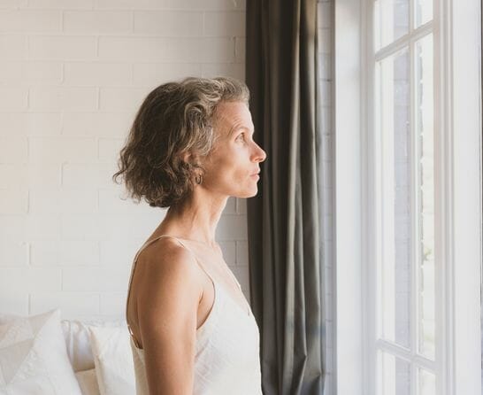 middle aged woman looking out the window