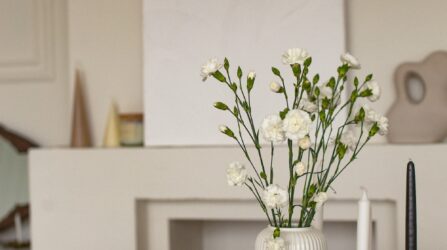flowers on a table with a fireplace in the background