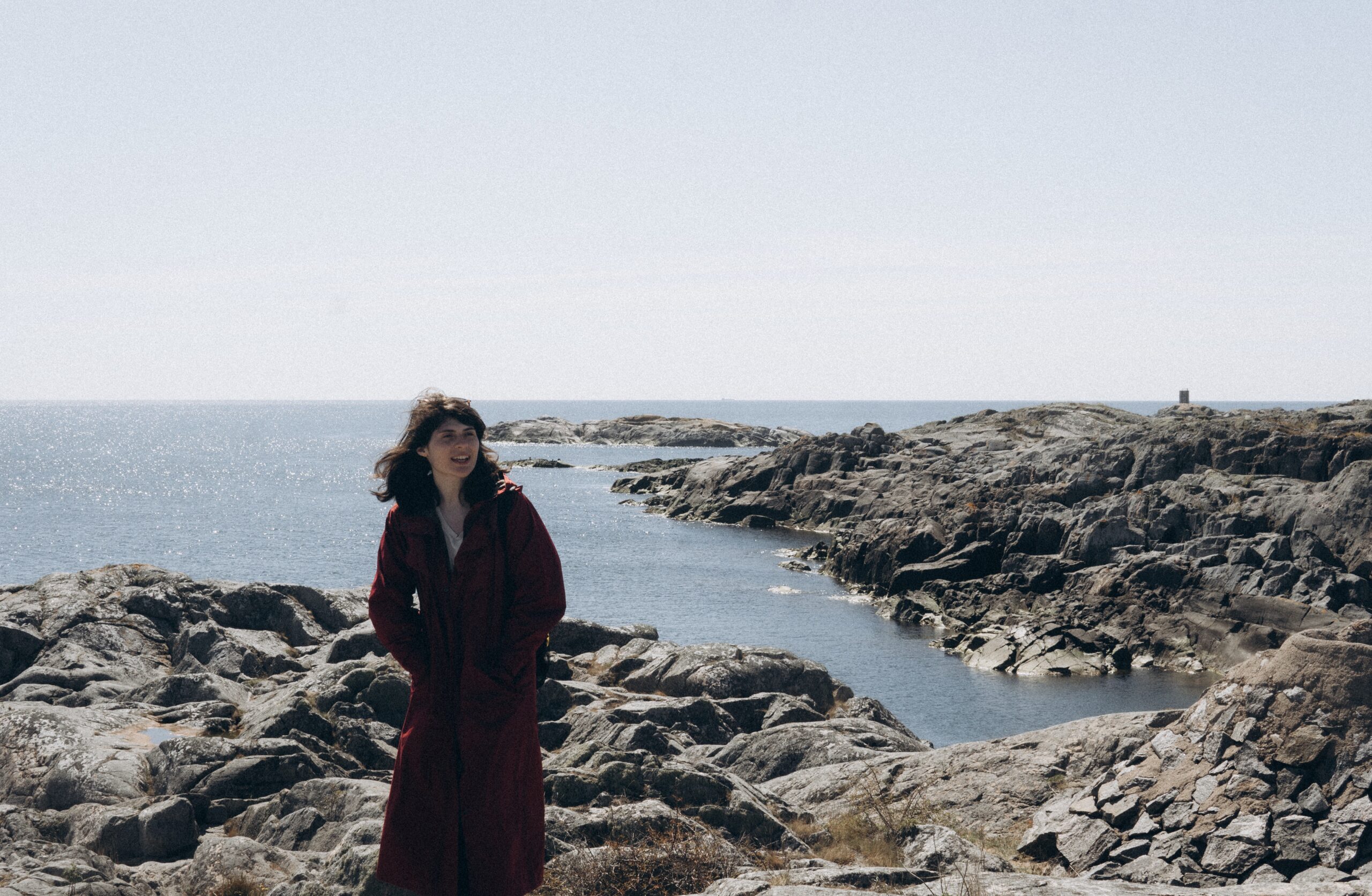 women in coat next to the ocean